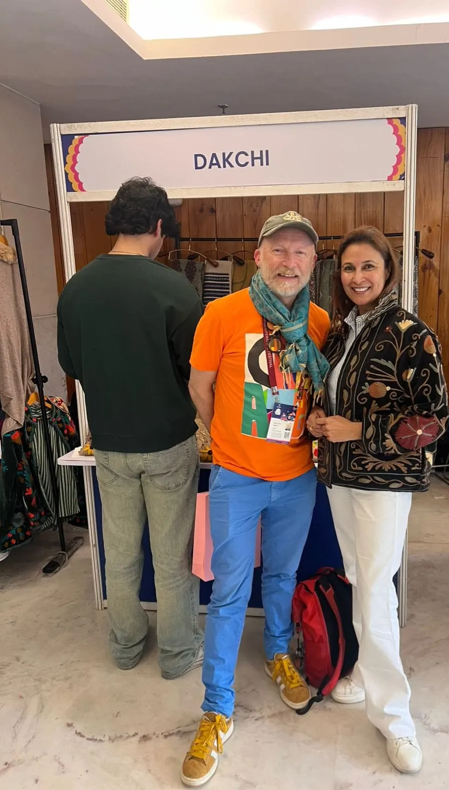 Visitors at the Dakchi stall, one in a bright orange T-shirt and one in an embroidered jacket