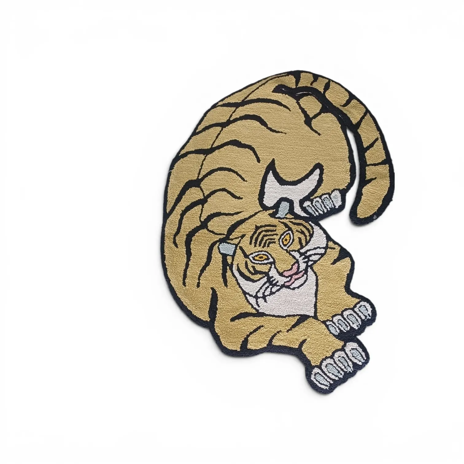 A crouching tiger rug in soft sand gold with black stripes, shaped to the animal outline, on a white background